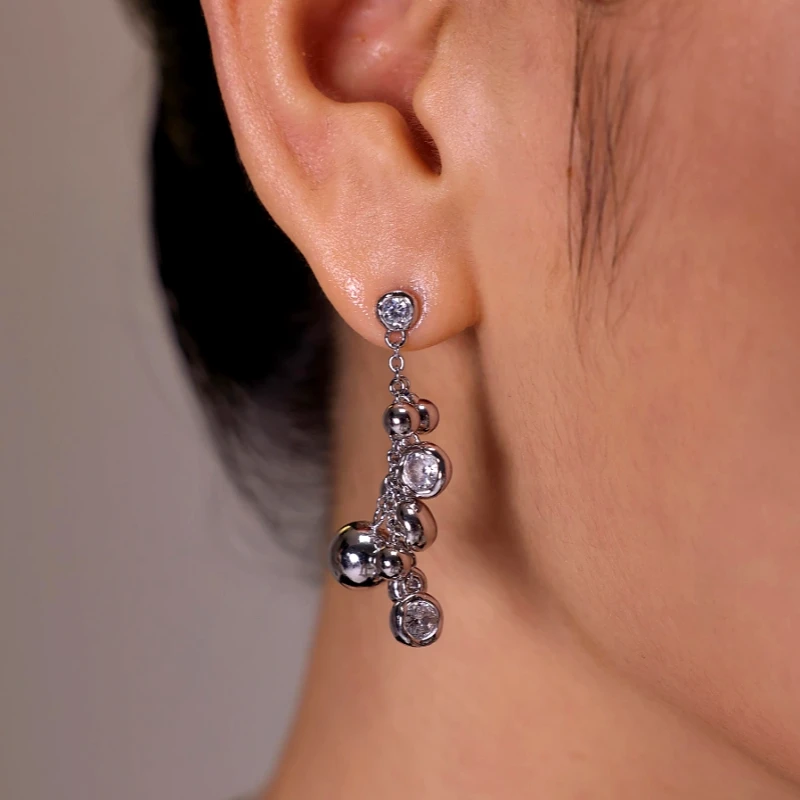 Silver CZ bubble drop dangle earring worn on woman's ear