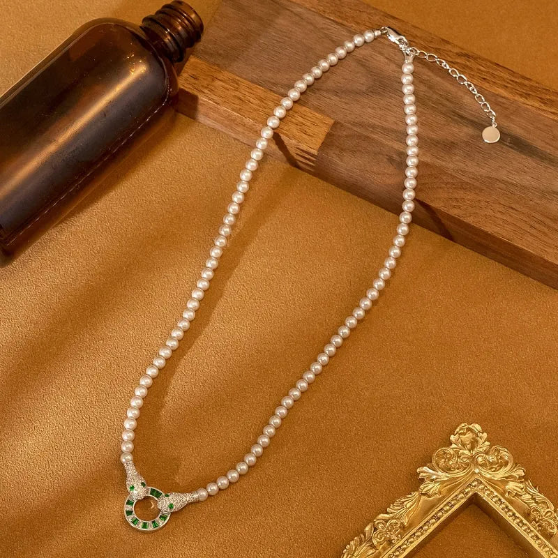 White Pearl Necklace with Silver Snake Pendant and Green Gemstones