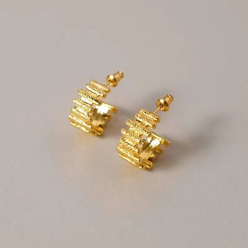 Model showcasing the dangle and style of the 18K Gold-Plated folds C-Shaped Earrings