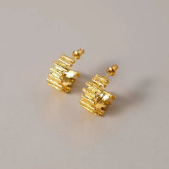 Model showcasing the dangle and style of the 18K Gold-Plated folds C-Shaped Earrings