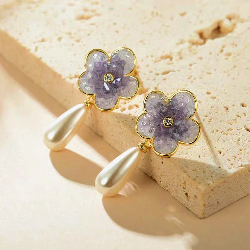 Model showcasing the dangle and style of the 18K Gold-plated Purple Flower Pearl Earrings