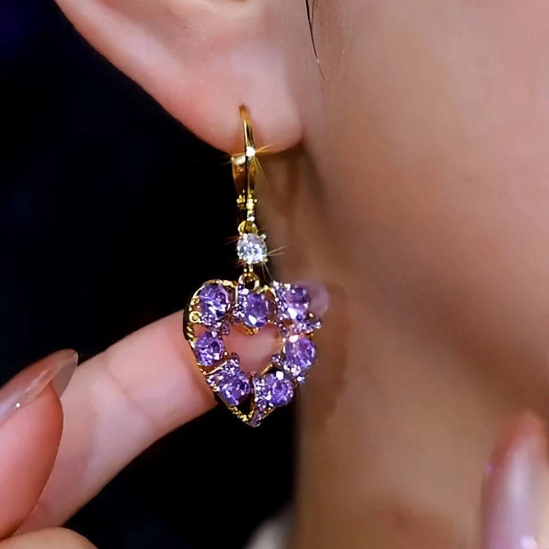 Model showcasing the dangle and style of the 14K Gold-Plated Elegant Purple Zircon Heart Earrings