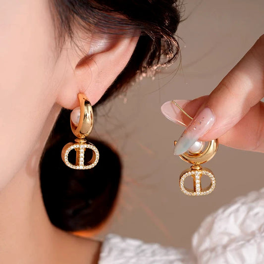 Model showcasing the dangle and style of the 14K Gold-Plated Elegant Shiny Pearl Earrings