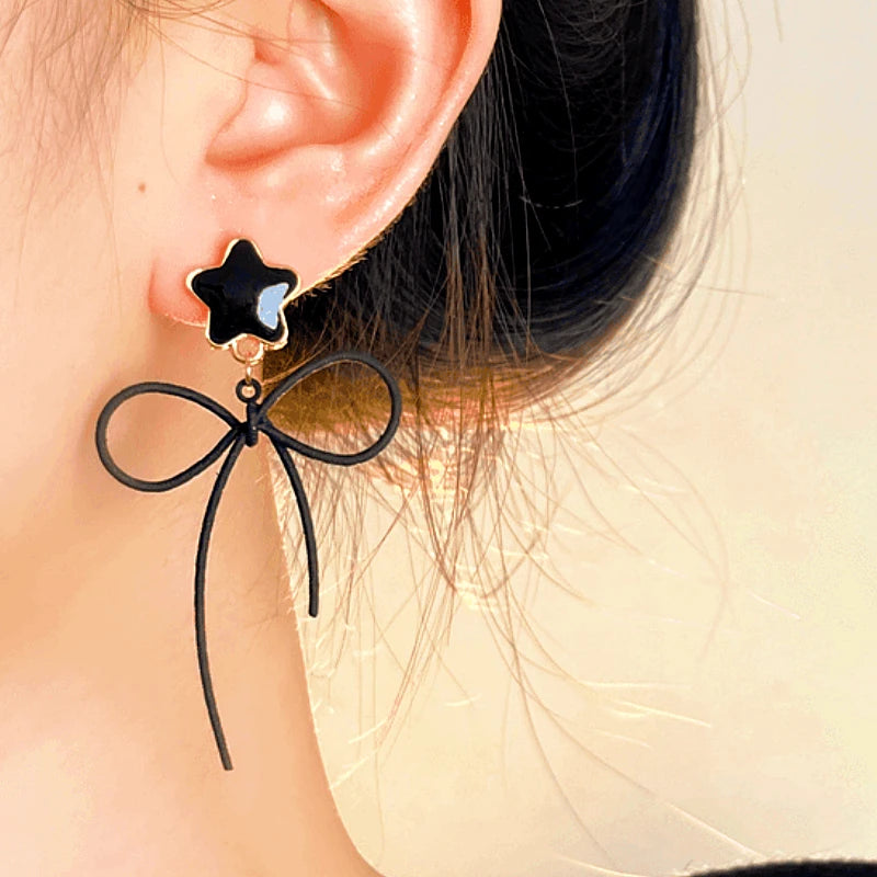 Model showcasing the dangle and style of the Halloween 14K Gold-Plated Star Bow Cat Earrings