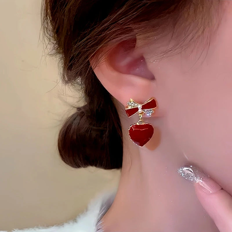 Model showcasing the dangle and style of the Silver Post Bow Heart Earrings