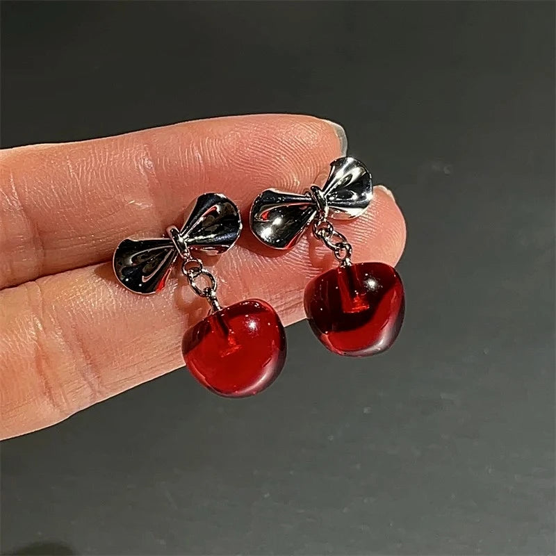 Model showcasing the dangle and style of the Silver Post Christmas Bow Cherry Earrings