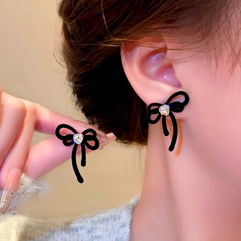 Model showcasing the dangle and style of the Silver Post Christmas Bow Earrings
