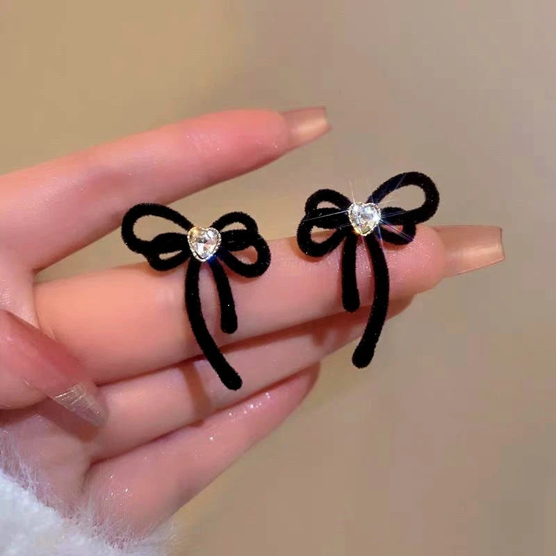 Angled view of the Silver Post Christmas Bow Earrings