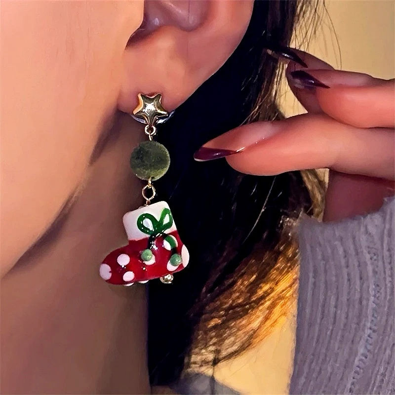 Model showcasing the dangle and style of the Silver Post Christmas Green Wool Ball Sock Earrings