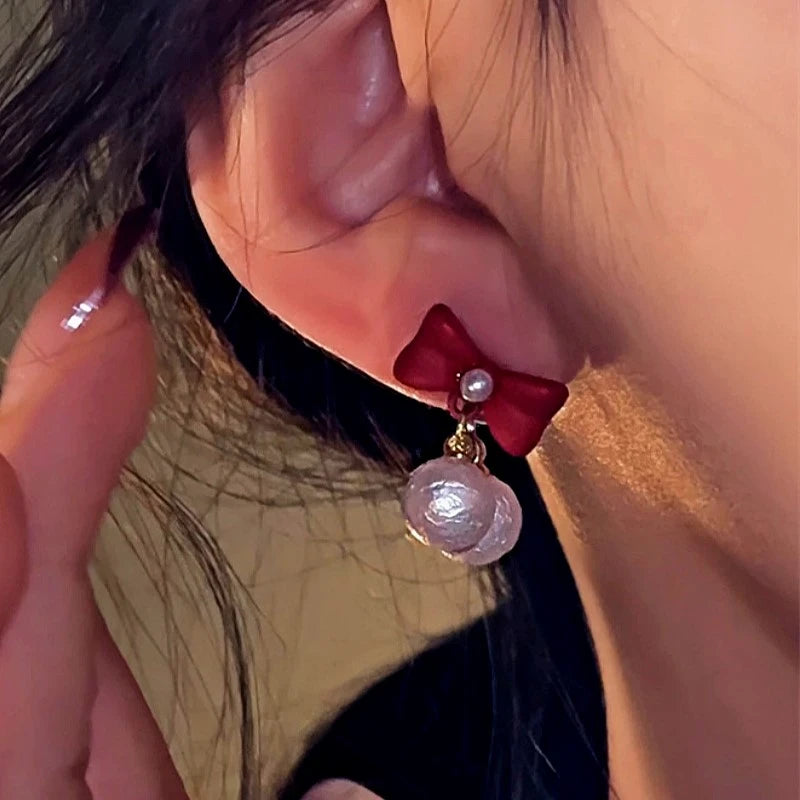 Close-up detail of the sparkling zircons and plating on the Red Bow Earrings