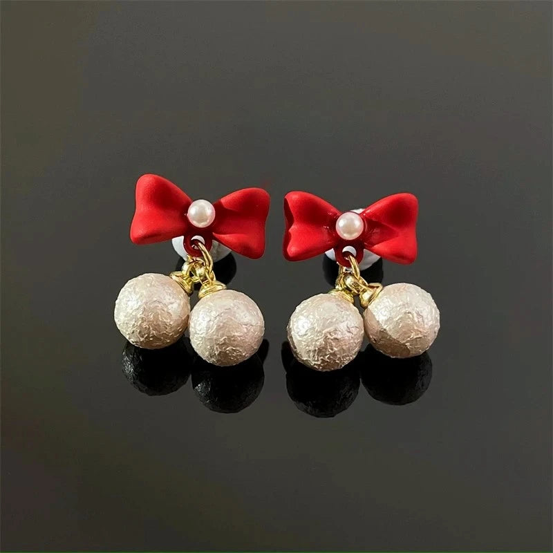 Model showcasing the dangle and style of the Silver Post Christmas Red Bow Bead Earrings