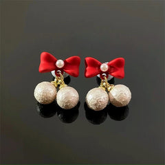 Model showcasing the dangle and style of the Silver Post Christmas Red Bow Bead Earrings