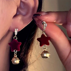Model showcasing the dangle and style of the Silver Post Christmas Star Bell Wine Red Flocking Earrings