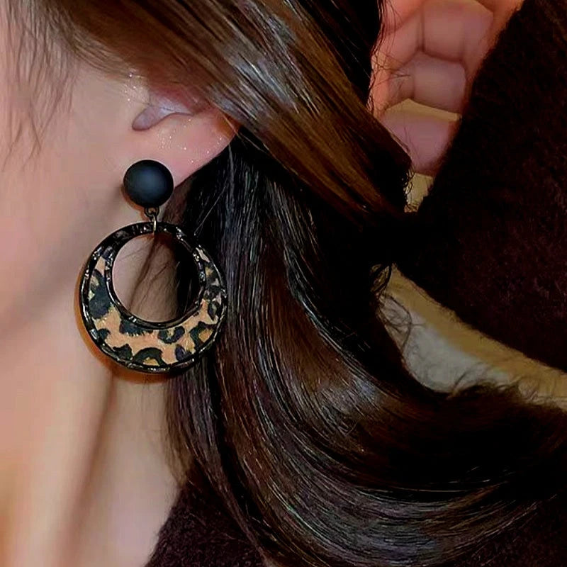 Model showcasing the dangle and style of the Silver Post Leopard Hoop Earrings