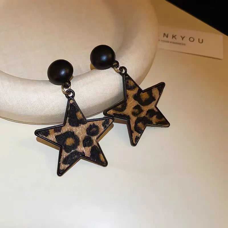 Angled view of the Silver Post Leopard Print Star Earrings