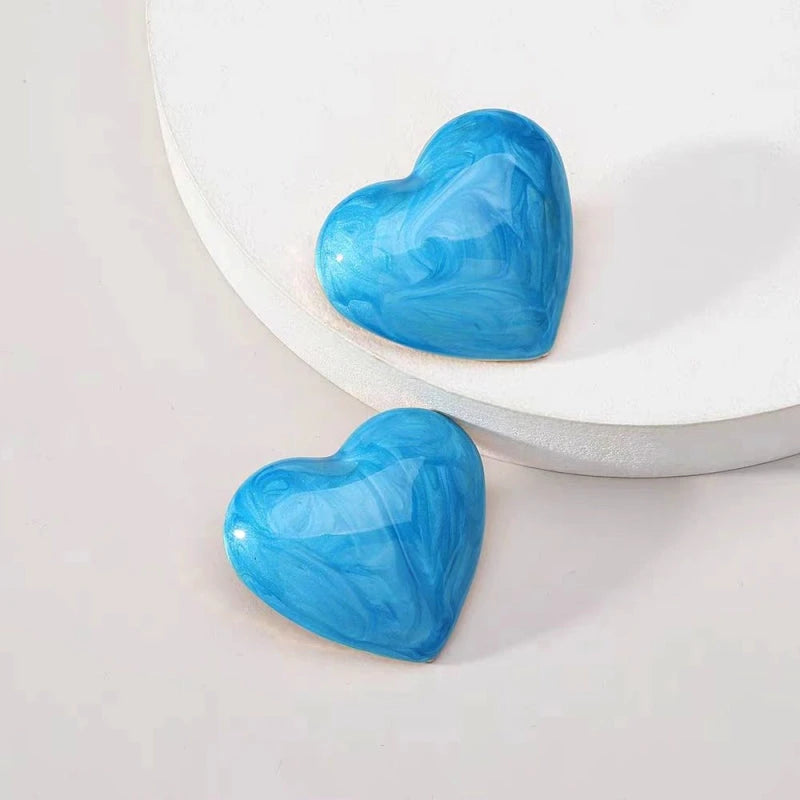 Model showcasing the dangle and style of the Silver Post Painted Heart Stud Earrings