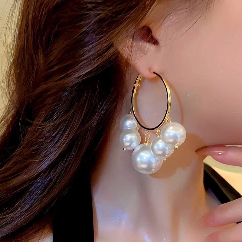 Model showcasing the dangle and style of the Silver Post Pearl Tassel Hoop Earrings