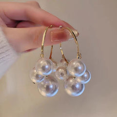 Angled view of the Silver Post Pearl Tassel Hoop Earrings