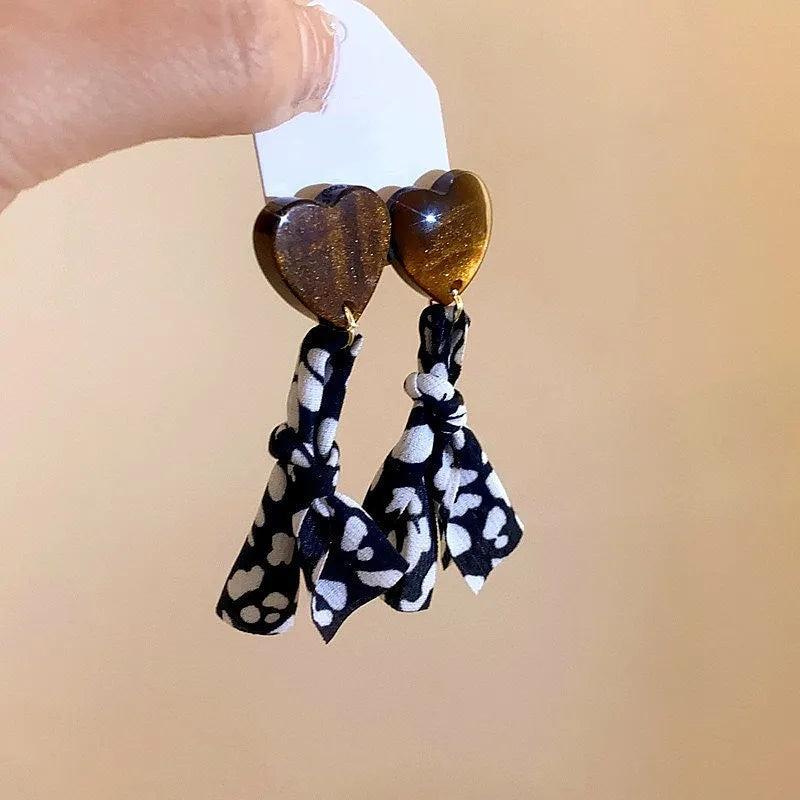 Angled view of the Silver Post Resin Heart Polka Dot Earrings