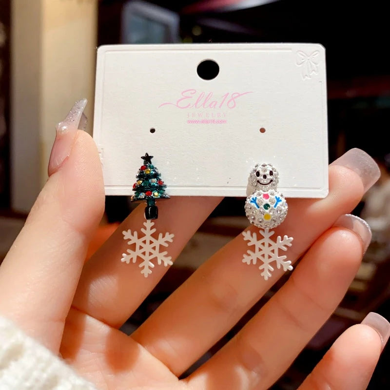 Model showcasing the dangle and style of the Silver Post Snowman Christmas Tree Snowflake Earrings
