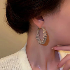 Angled view of the Silver Post Wrinkled Leather Earrings