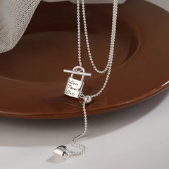 Sterling Silver Adjustable Small Silver Lock Heart Tassel Necklace worn to showcase its length and pendant detail