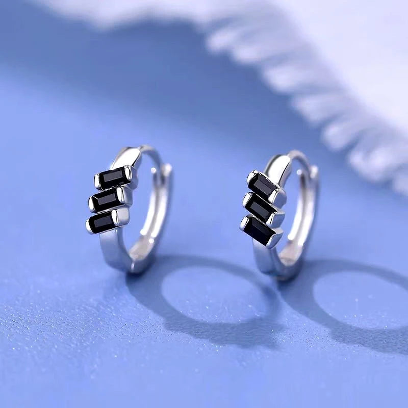 Model showcasing the dangle and style of the Sterling Silver Black Cube Hoop Earrings