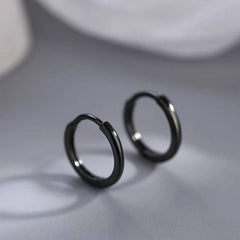Model showcasing the dangle and style of the Sterling Silver Black Small Hoop Earrings