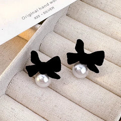 Angled view of the Sterling Silver Bow Pearl Earrings