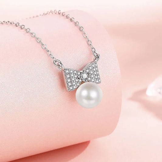 Sterling Silver Bow Pearl Necklaces worn to showcase its length and pendant detail