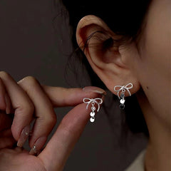 Model showcasing the dangle and style of the Sterling Silver Bow Tassel Earrings