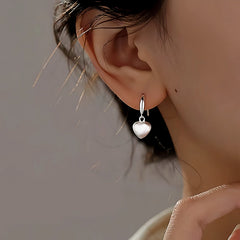 Model showcasing the dangle and style of the Sterling Silver Brushed Frosted Heart Earrings