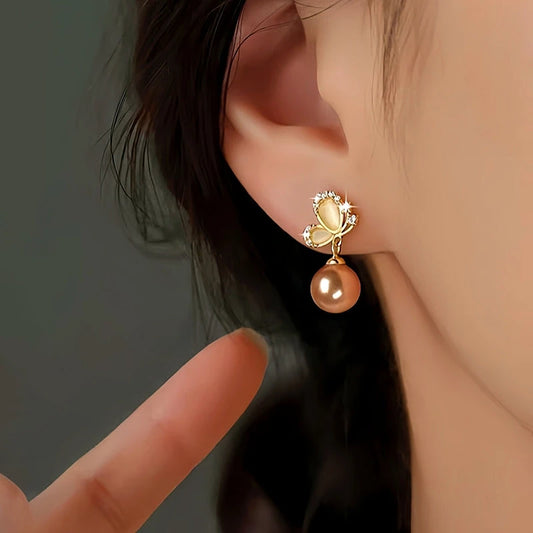 Model showcasing the dangle and style of the Sterling Silver Butterfly Pearl Earrings