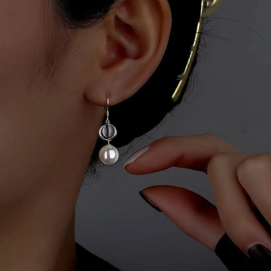 Model showcasing the dangle and style of the Sterling Silver Cat's Eye Stone Pearl Ear Hooks