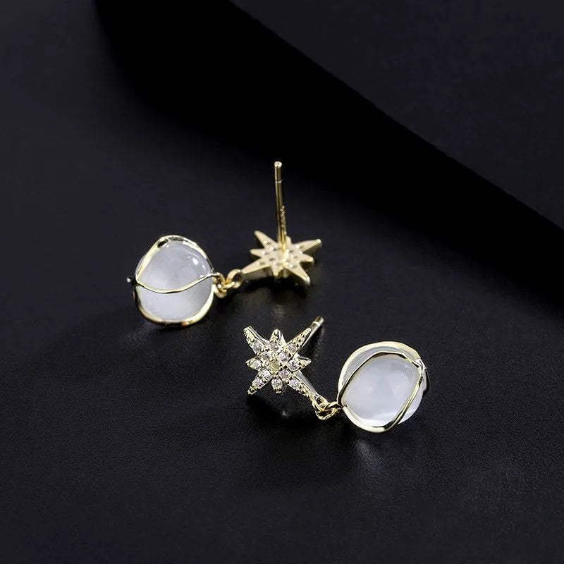 Model showcasing the dangle and style of the Sterling Silver Cat's Eye Stone Zircon Eight-Pointed Star Earrings