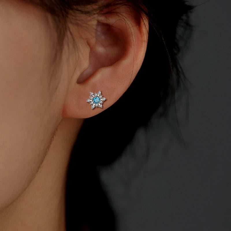 Model showcasing the dangle and style of the Sterling Silver Christmas Blue Diamond Snowflake Stud Earrings