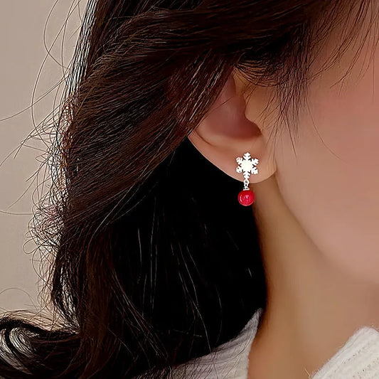 Model showcasing the dangle and style of the Sterling Silver Christmas Pearl Snowflake Asymmetrical Earrings