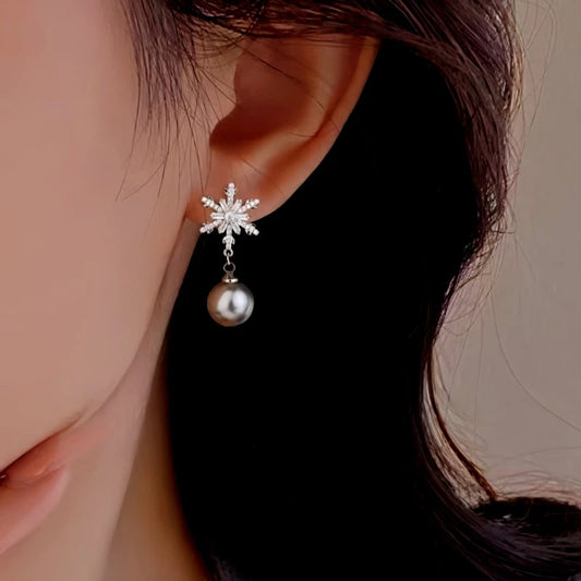 Model showcasing the dangle and style of the Sterling Silver Christmas Rhinestone Snowflake Pearl Earrings