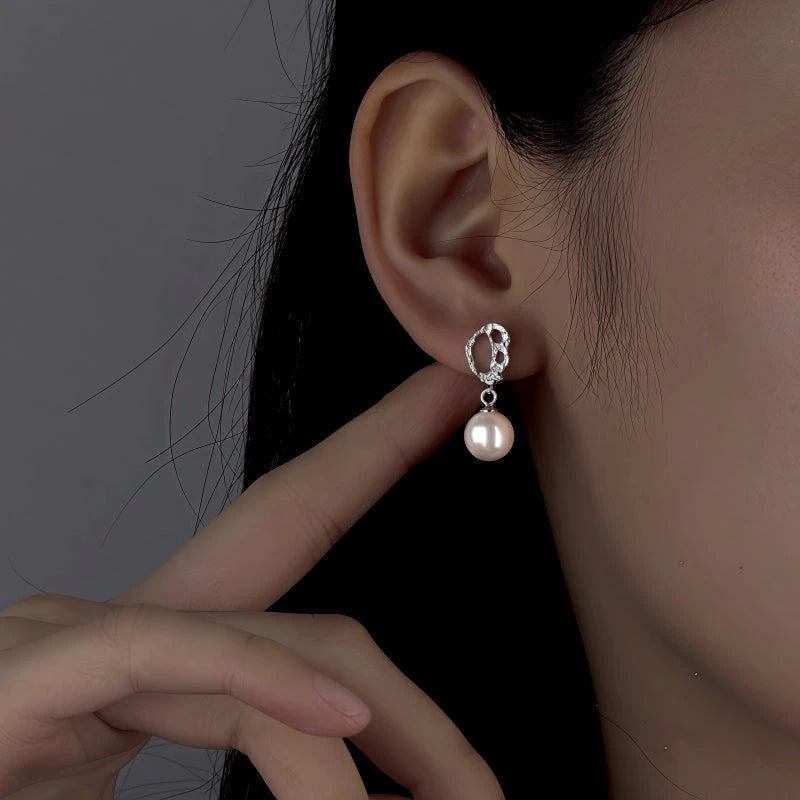 Angled view of the Sterling Silver Clown Pattern Pearl Earrings