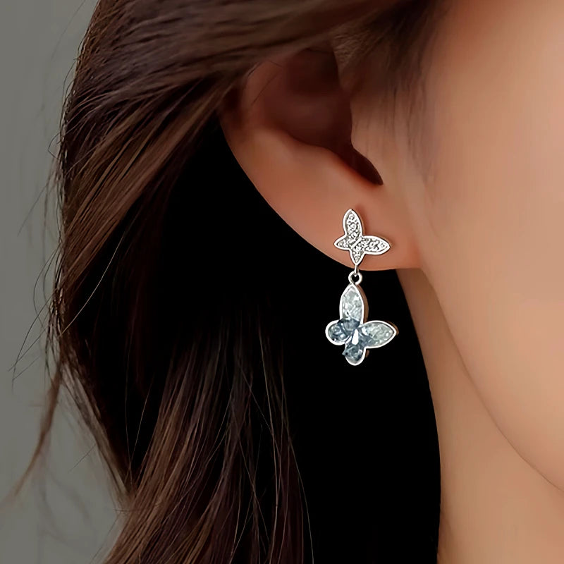 Model showcasing the dangle and style of the Sterling Silver Diamond Butterfly Earrings