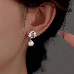 Model showcasing the dangle and style of the Sterling Silver Diamond Cat's Eye Hoop Pearl Earrings