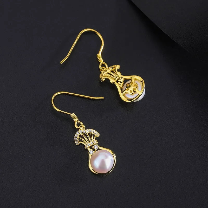 Model showcasing the dangle and style of the Sterling Silver Diamond Lucky Bag Pearl Ear Hooks