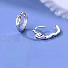 Model showcasing the dangle and style of the Sterling Silver Dolphin Hoop Earrings