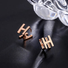 Angled view of the Sterling Silver Double-Sided Letter H Stud Earrings