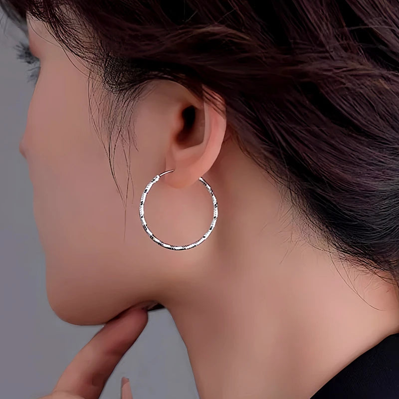 Angled view of the Sterling Silver Edge Face Hoop Earrings