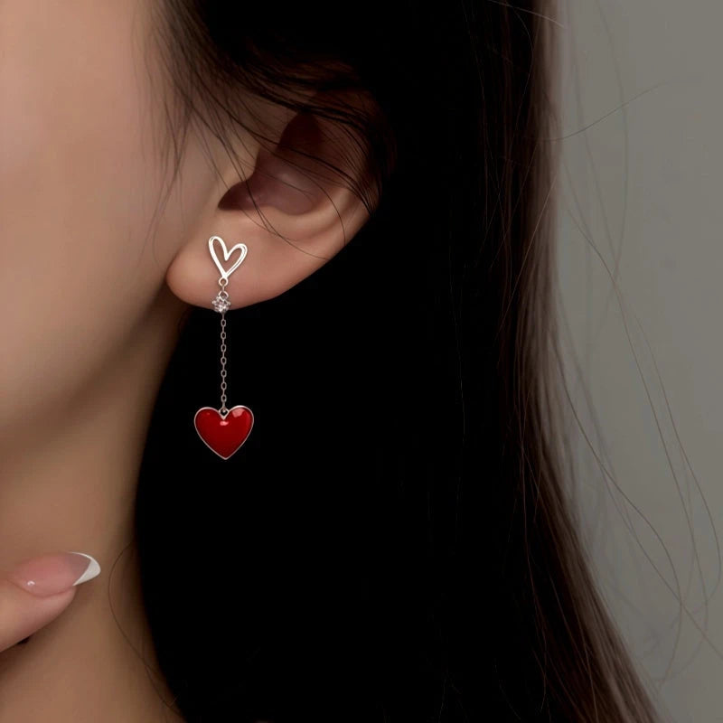 Model showcasing the dangle and style of the Sterling Silver Elegant Asymmetrical Heart Earrings