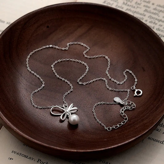 Sterling Silver Elegant Bow Pearl Necklace worn to showcase its length and pendant detail