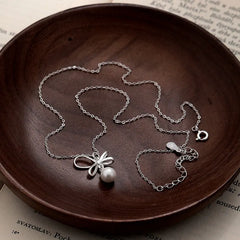 Sterling Silver Elegant Bow Pearl Necklace worn to showcase its length and pendant detail