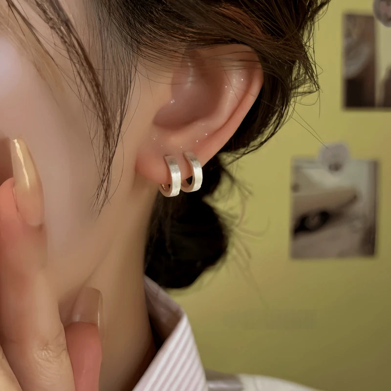 Model showcasing the dangle and style of the Sterling Silver Elegant Brushed Hoop Earrings