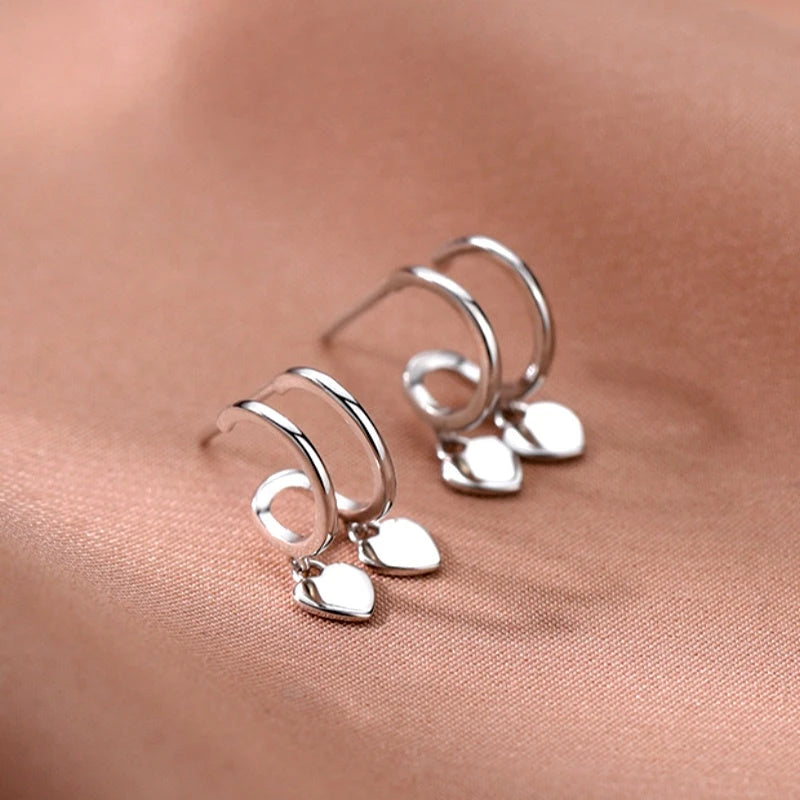 Model showcasing the dangle and style of the Sterling Silver Elegant Double-Layer Heart Earrings
